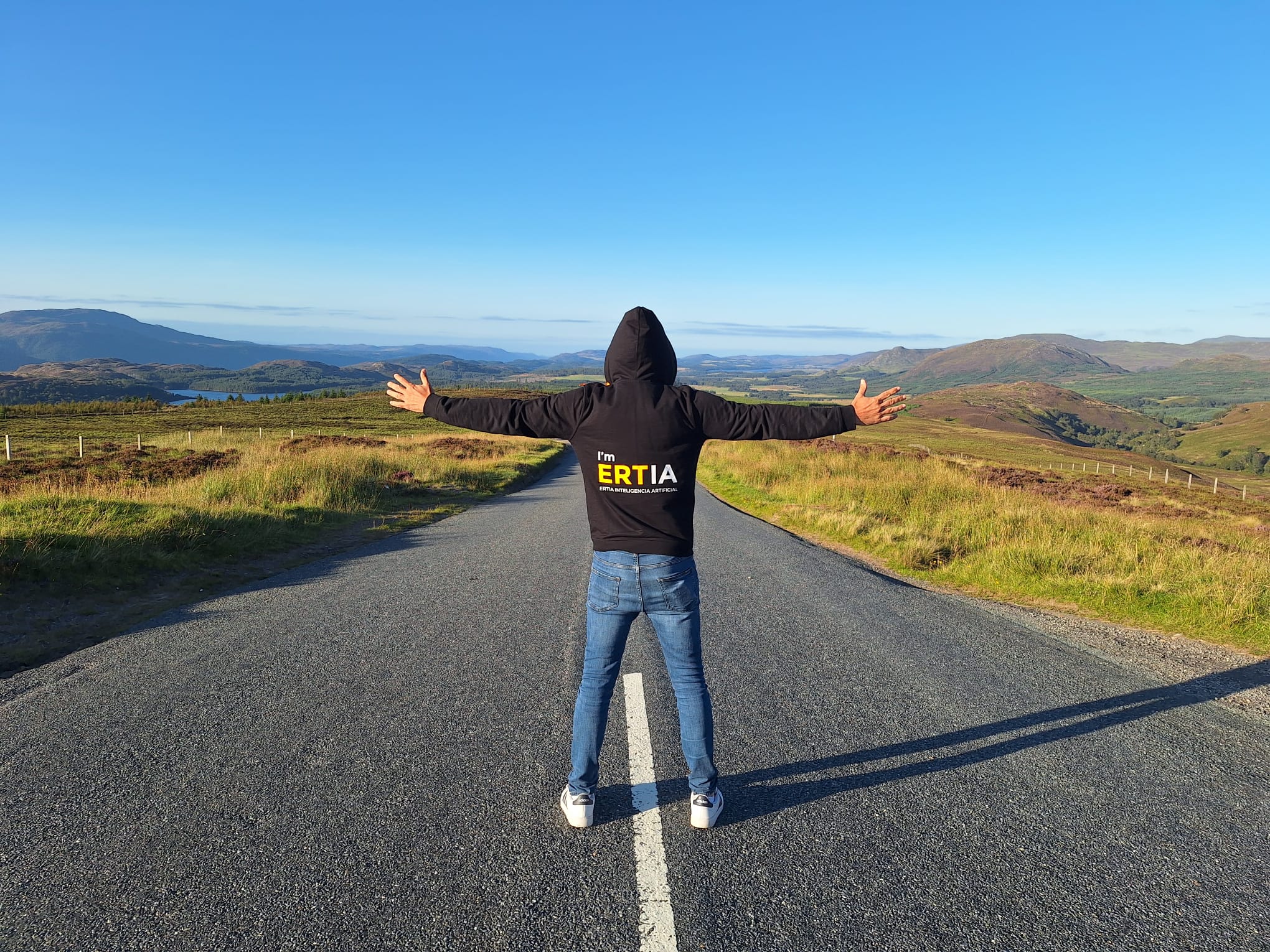 Una persona con sudadera de ERTIA en una carretera entre montañas